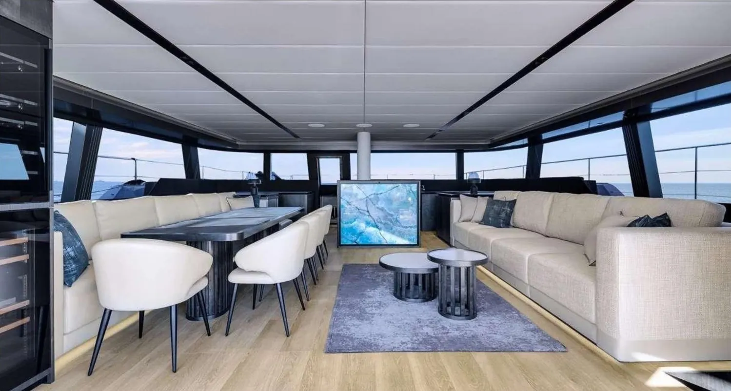 Main salon with dining table and panoramic glazing