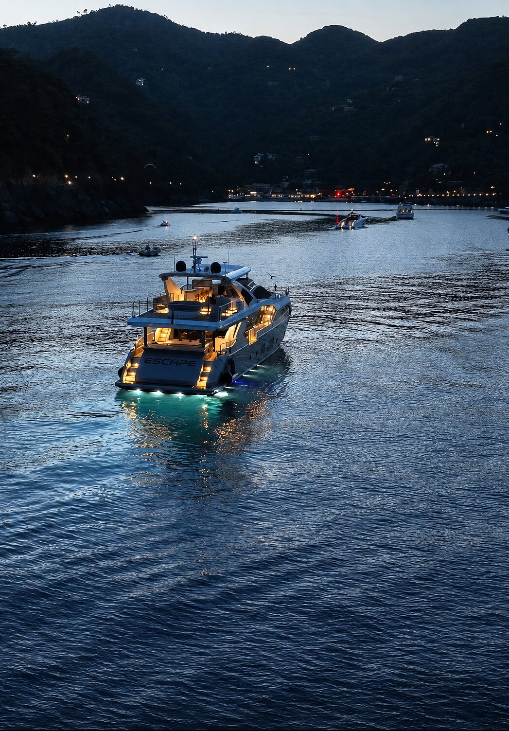 M/Y ESCAPE at dusk with sixteen underwater lights lit